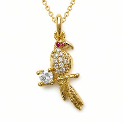 Dije dorado de loro en pave posado en una rama