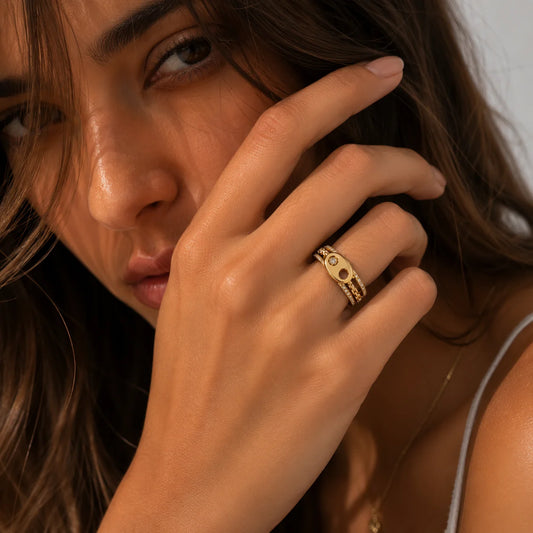 Mujer con la mano en el rostro y el anillo de eslabón puesto