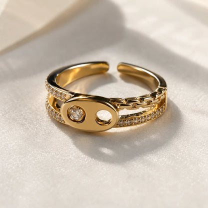 Anillo dorado ajustable de eslabones con dos circonias engastadas y banda en pavé