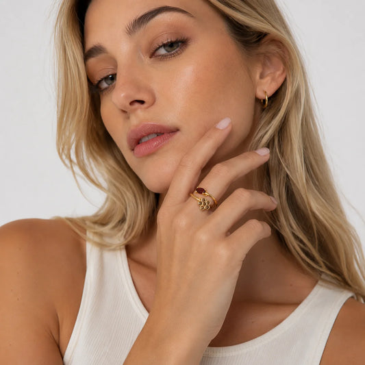 Mujer rubia con top blanco y el anillo de flor con piedra roja puesto