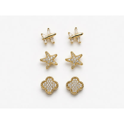 Set de tres pares de aretes dorados en pavé con forma de avión, estrella y trébol