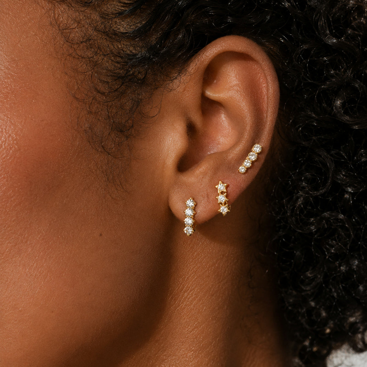 Aretes en pavé de circonias puestos en la oreja, en otro plano