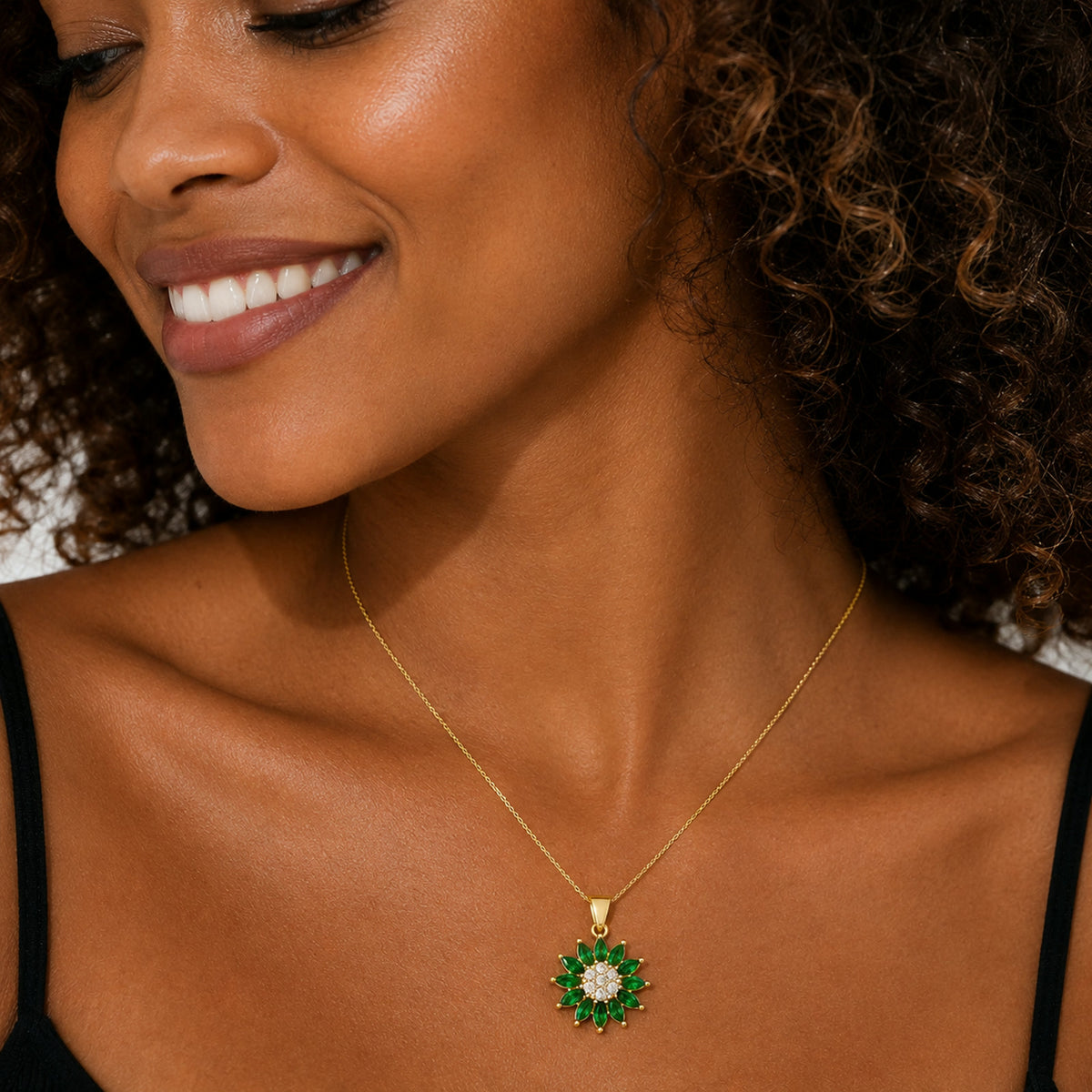 Dije de flor con piedras verdes puesto al cuello
