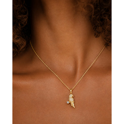 Dije de loro en pavé puesto al cuello, en otro plano