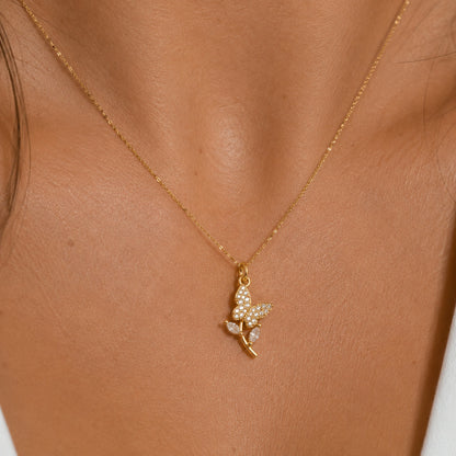 Dije de mariposa en pavé puesto al cuello, en otro plano
