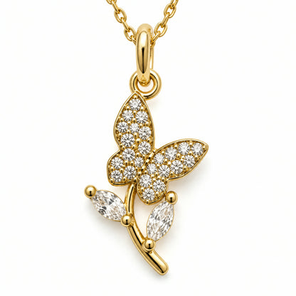 Dije de mariposa en pave posada sobre una rama, con dos piedras colgantes