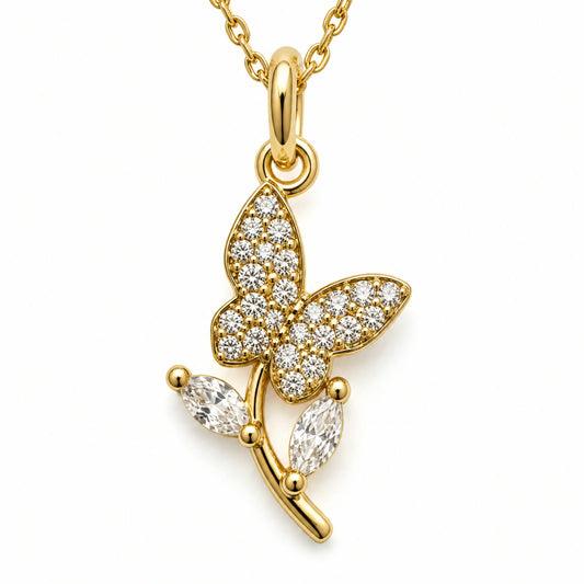 Dije de mariposa en pave posada sobre una rama, con dos piedras colgantes