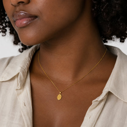 Dije de la medalla de la Virgen Milagrosa puesto al cuello