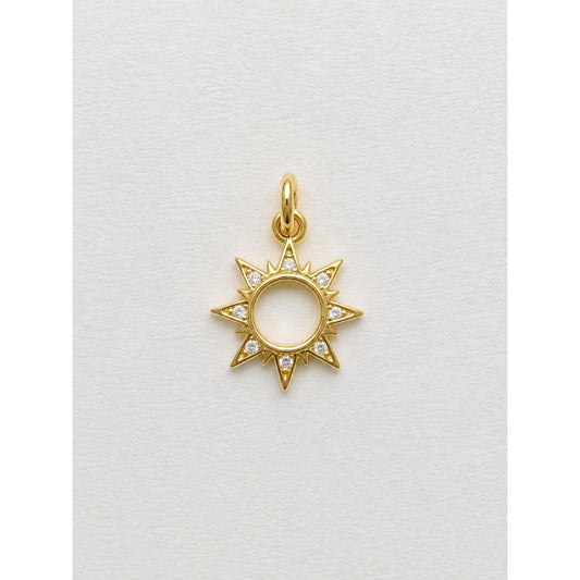 Dije dorado de sol con rayos y contorno en pavé de circonias
