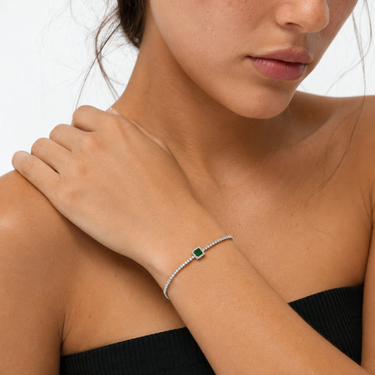 Pulsera tenis con piedra verde puesta en la muñeca